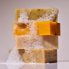 Stack of vegan, non-toxic soap bars with visible bubbles on a neutral background