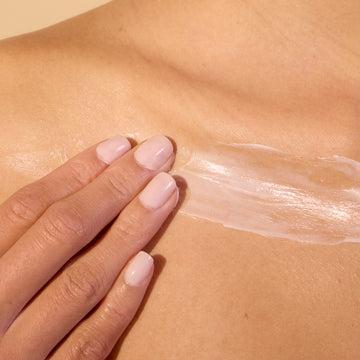 Person applying moisturizer on chest area