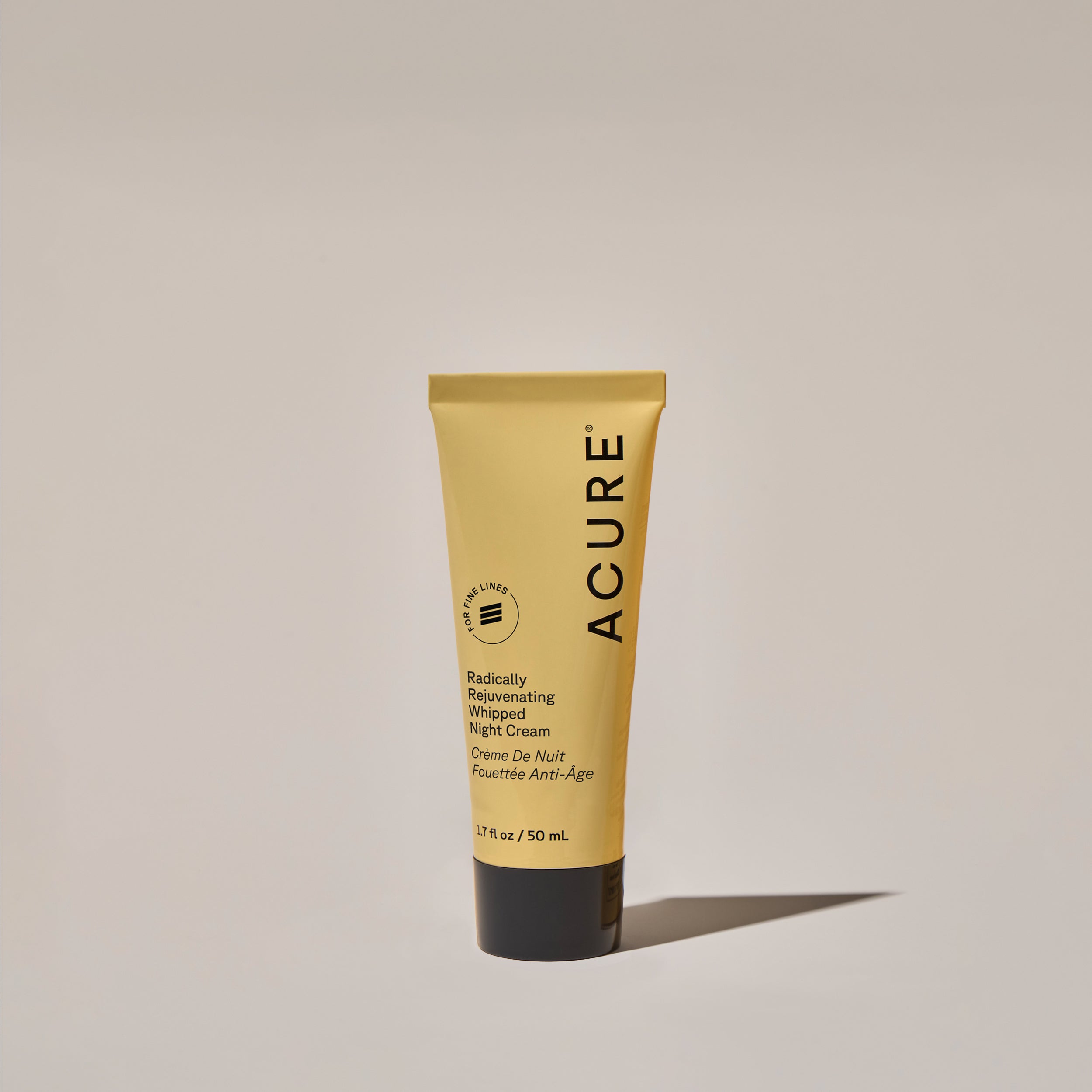 A yellow tube of ACURE Whipped Night Cream against a neutral background.