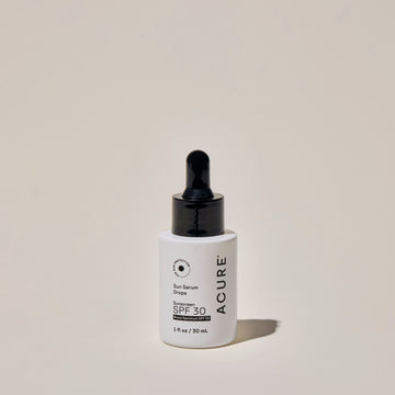 A bottle of Sun Serum Drops with SPF 30, featuring a dropper nozzle, labeled with the brand ACURE and product details.