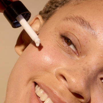 Woman applying Serum on her face with a dropper