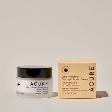 Ultra hydrating overnight dream cream jar next to its packaging labeled ACURE on a neutral background