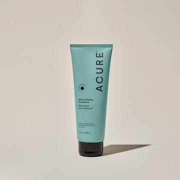 A tube of ACURE Ultra Hydrating Conditioner against a neutral background.