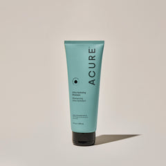 A tube of ACURE Ultra Hydrating Shampoo against a neutral background.