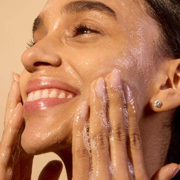 Woman applying brightening cleanser