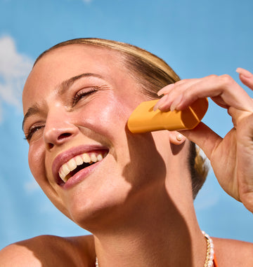 Woman using Acure Invisible Sunscreen – sheer, blendable SPF for invisible sun protection on all skin tones