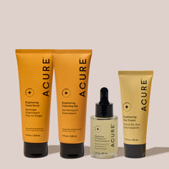 Acure skincare products including a scrub, gel, cream, and serum on a neutral background