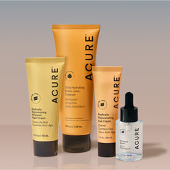 Acure skincare products including a tube, bottle, and serum on a gradient background