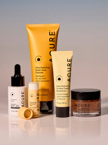 Acure skincare products including a tube, bottle, and jar on a gradient background