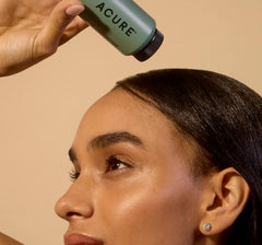 Woman applying Acure Dry Shampoo