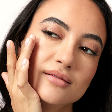 Woman applying face moisturizer