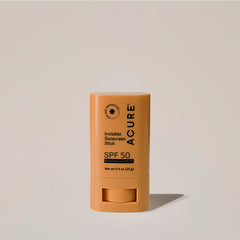 Acure Invisible Sunscreen Stick SPF 50 in a yellow twist-up tube, standing upright on a neutral background.