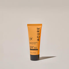 Acure sunscreen tube with SPF 30 on a neutral background