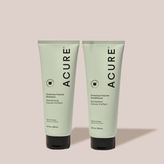 Acure Vivacious Volume Shampoo and Conditioner tubes on a light background