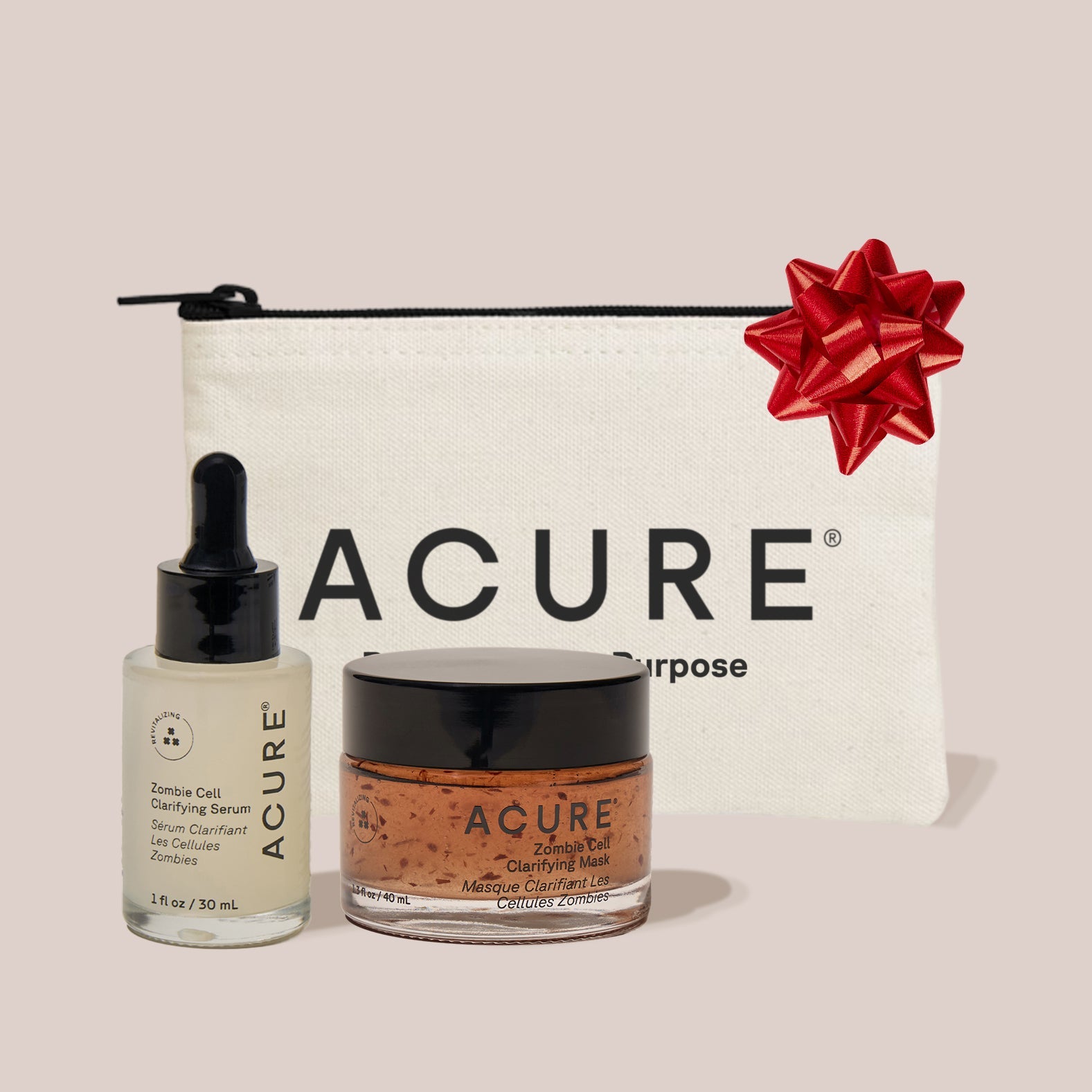 Acure skincare products with a pouch and red bow on a light pink background
