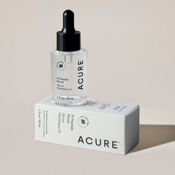 Acure AI Peptide Serum bottle with dropper on its box against a beige background