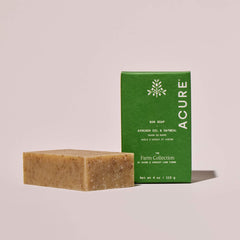Avocado oil and oatmeal Bar of soap and green Acure x Apricot Lane Farm  packaging on a beige background
