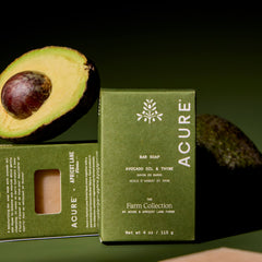 Acure bar soap with avocado and packaging on a green background