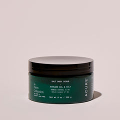 Acure body salt scrub jar on a beige background