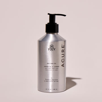 Acure body wash bottle on a light pink background