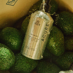 Acure Farm Collection by Apricot Lane Farms oil bottle with avocadoes on a wooden surface