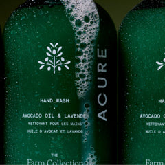 Green Acure hand wash bottle with avocado oil and lavender on a dark background