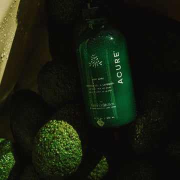 Green bottle of Acure on a textured surface