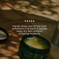 Jar of exfoliating scrub with a five-star rating and review on a wooden surface