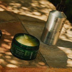 Acure jar and bottle on a stone surface with natural light