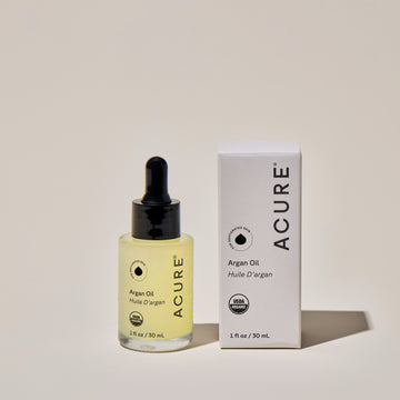 ACURE Organic Argan Oil Bottle next to a box with product details– Hydrating Multi-Use Oil for Dry Hair, Cuticles & Glowing Skin