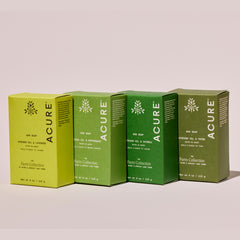 Four green boxes of Acure bar soap on a beige background