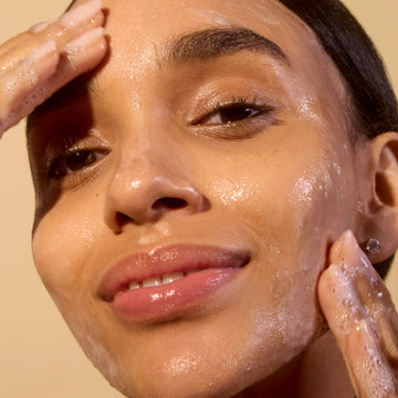 Woman applying Acure Cleansing gel