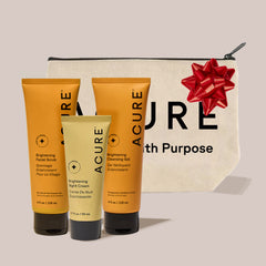 Acure skincare products with a pouch and red bow on a light background