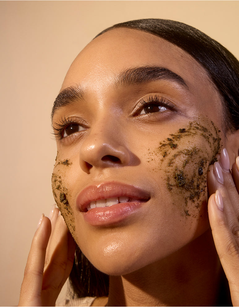 Woman applying Acure Facial scrub
