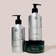 Acure Organics skincare products including body wash, lotion, and scrub on a beige background