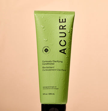 Curiously Clarifying Conditioner tube with water droplets on and around it