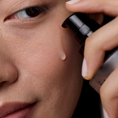 Person applying makeup with a brush to their face