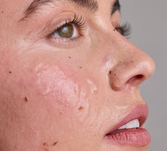 Close-up of a person's face with zombie cell clarifying mask applied to the skin on a gray background