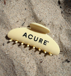 Beige ACURE Clip on sandy surface