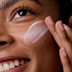 Close-up of a person applying cream to their face