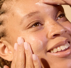 Person applying cream to their face with a close-up view