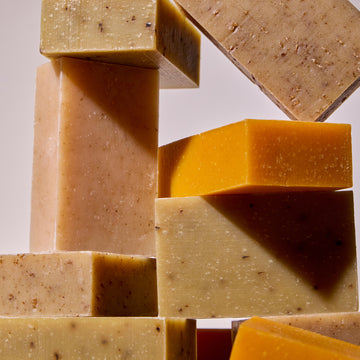 Acure's, non-toxic, vegan bar lavender, oatmeal, thyme and peppermint bar soaps on a light background