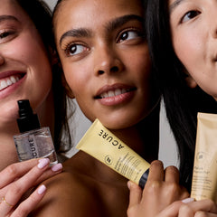 Three women holding skincare products with visible branding