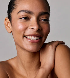 Woman with a radiant smile against a neutral background