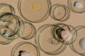 Glass containers with various shapes filled with different substances on a beige background