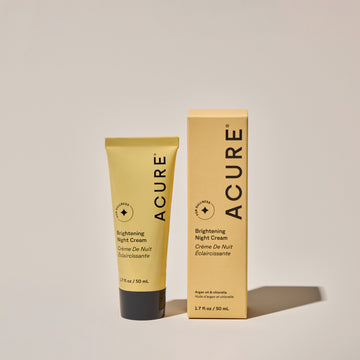 Brightening Night cream tube next to its packaging, labeled ACURE