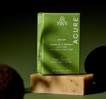 Acure bar soap with green packaging on a dark background