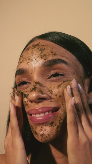 Video of a smiling woman applying Acure Facial Scrub on her face