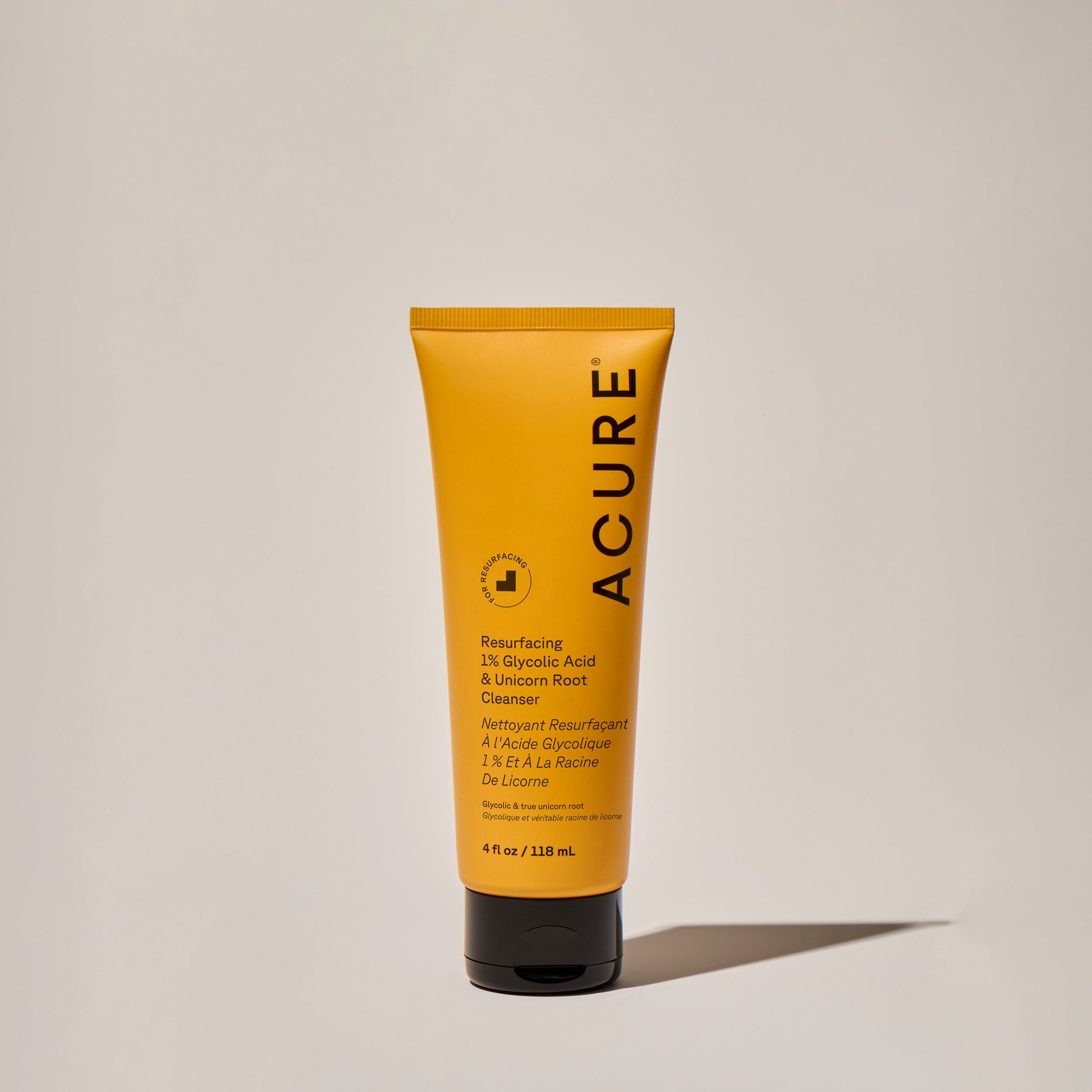 A yellow tube of ACURE Resurfacing 1% Glycolic Acid & Unicorn Root Cleanser on a neutral background.