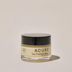 Acure Scar Treatment Balm jar on a beige background